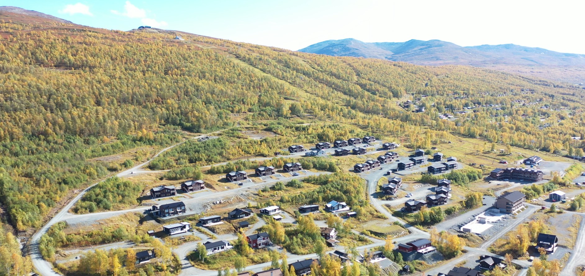 Flygvy över Hemavan med höstfärgade fjällen i bakgrunden